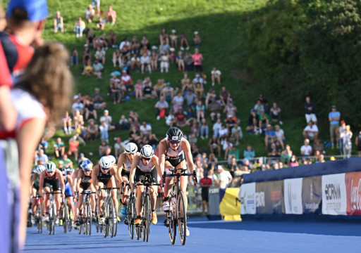 Gruppe Radfahrerinnen fahren durch den mit Zuschauern gefüllten Olympiapark